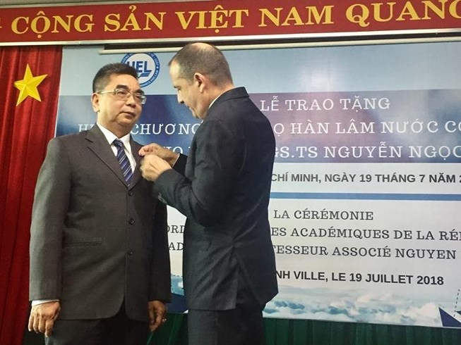 法國駐本市總領事Vincent Floreani向阮玉殿副教授頒授法國政府的翰林院棕櫚葉勳章。（圖源：PLO）