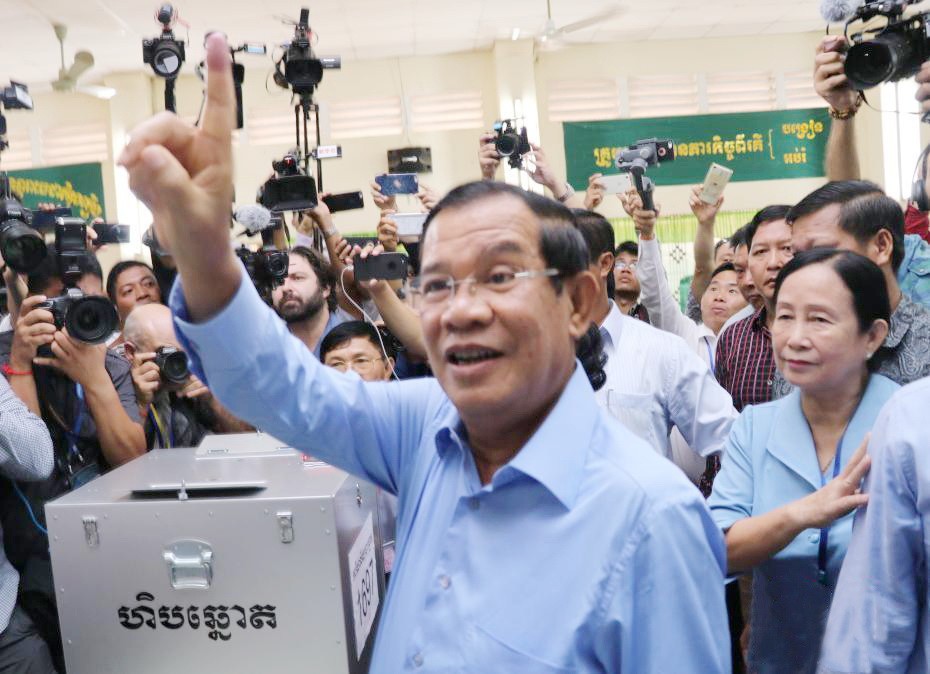 洪森在柬干拉省大金歐市大金歐分區投票點伸出已“投票印記”的右手食指。（圖源：互聯網）