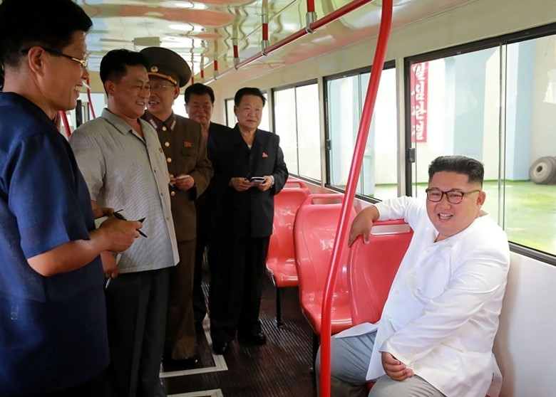 金正恩（白衣）視察無軌電車工廠。（圖源：KCNA）