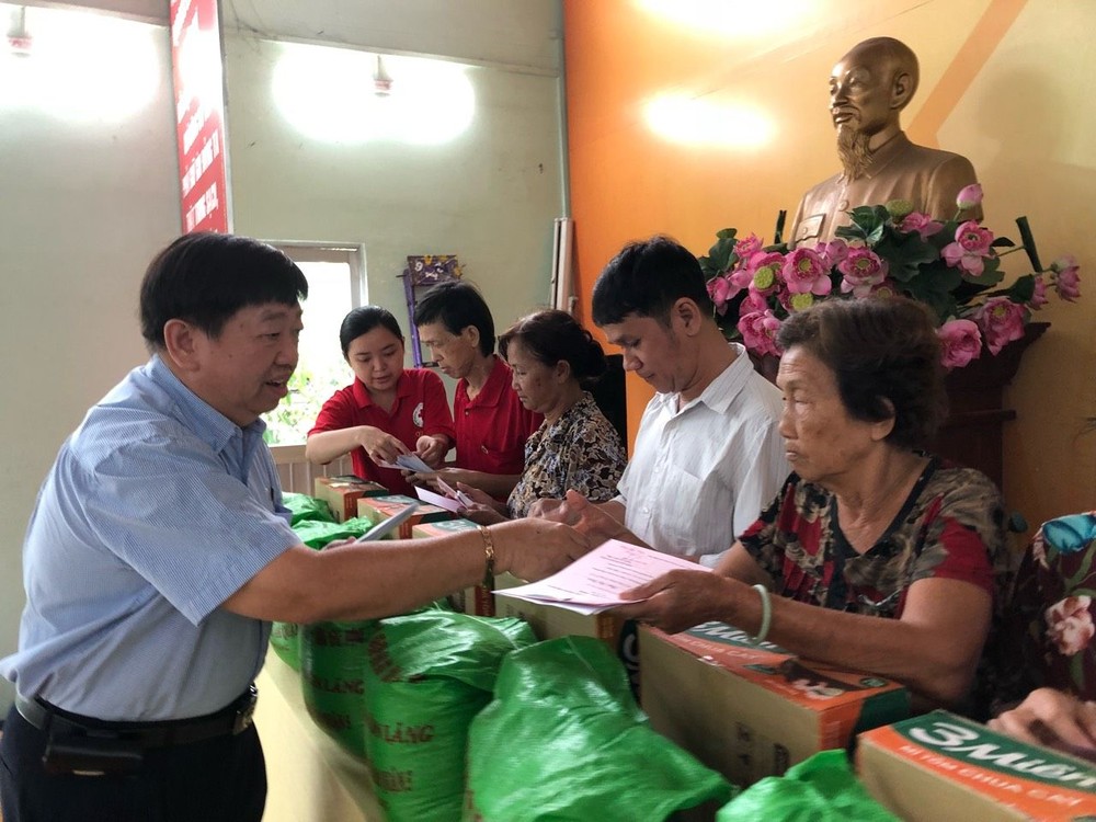 張子諒理事長贈送扶助金和禮物給越華長者。