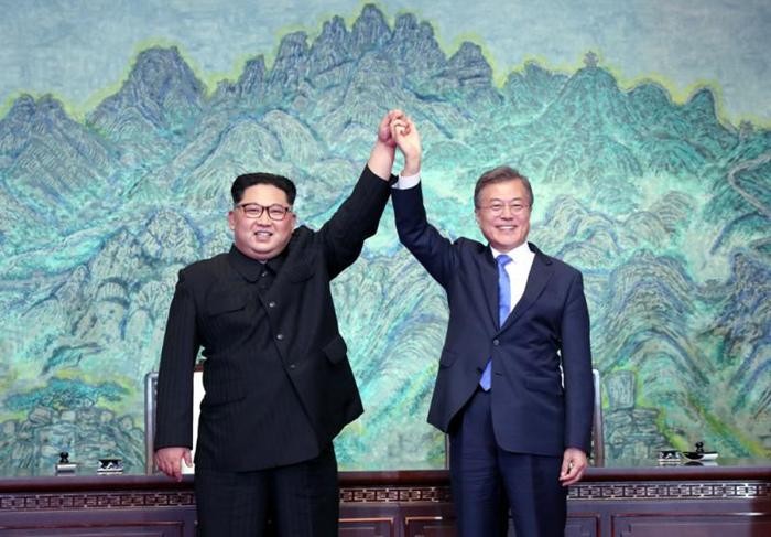 韓國防白皮書將刪“朝軍為敵”字句。圖為今年4月27日,朝鮮最高領導人金正恩與韓國總統文在寅攜手高舉,同賀簽署《板門店宣言》。(圖源:AFP)