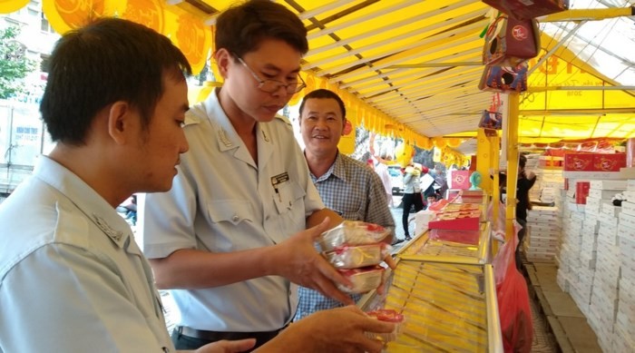 食品安全監察員在某一零售店取樣月餅送去檢測。(圖源:玉映)