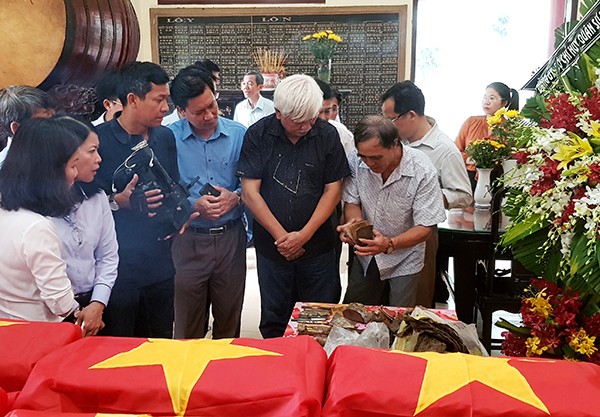 同奈省國會代表們在詳細查看有關出土的烈士遺物。（圖源：武宣）