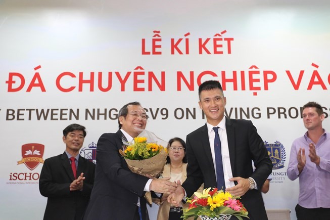 CV9足球學院主席、原國家足球隊選手黎功榮（前右）與阮煌教育集團代表簽訂合作協議後握手互送鮮花祝賀。（圖源：光廉）