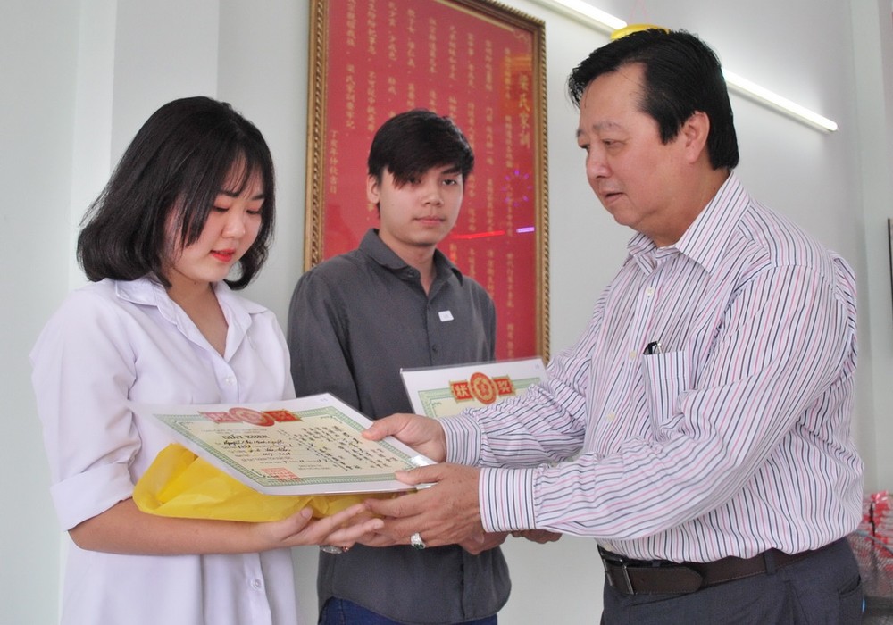 新屆理事長梁萬榮向大學生頒發獎學金。