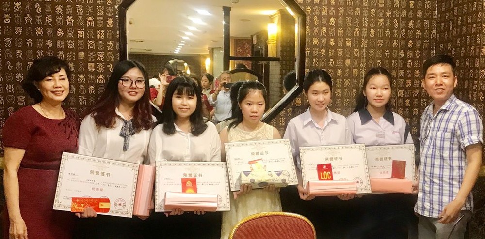 光芳盛股份有限公司郭虹(左一）和曾廣健（右一）代表三有實業貿易有限公司關達賢特向獲獎學生作出獎勵。