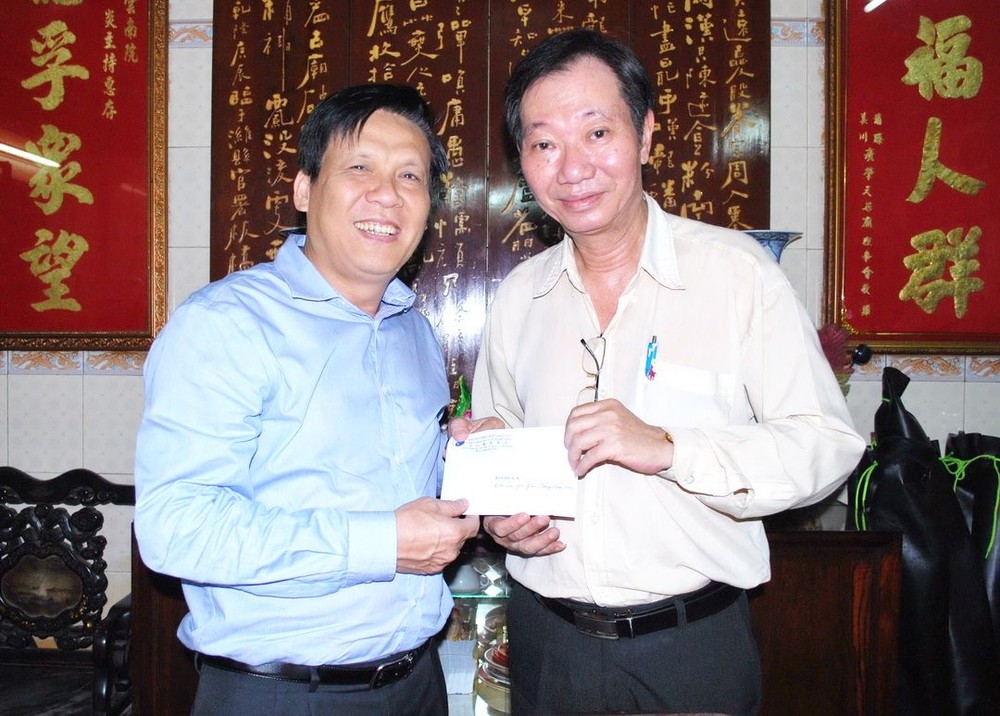 本報主編阮玉英(左)接受周華邦住持贊助善款。