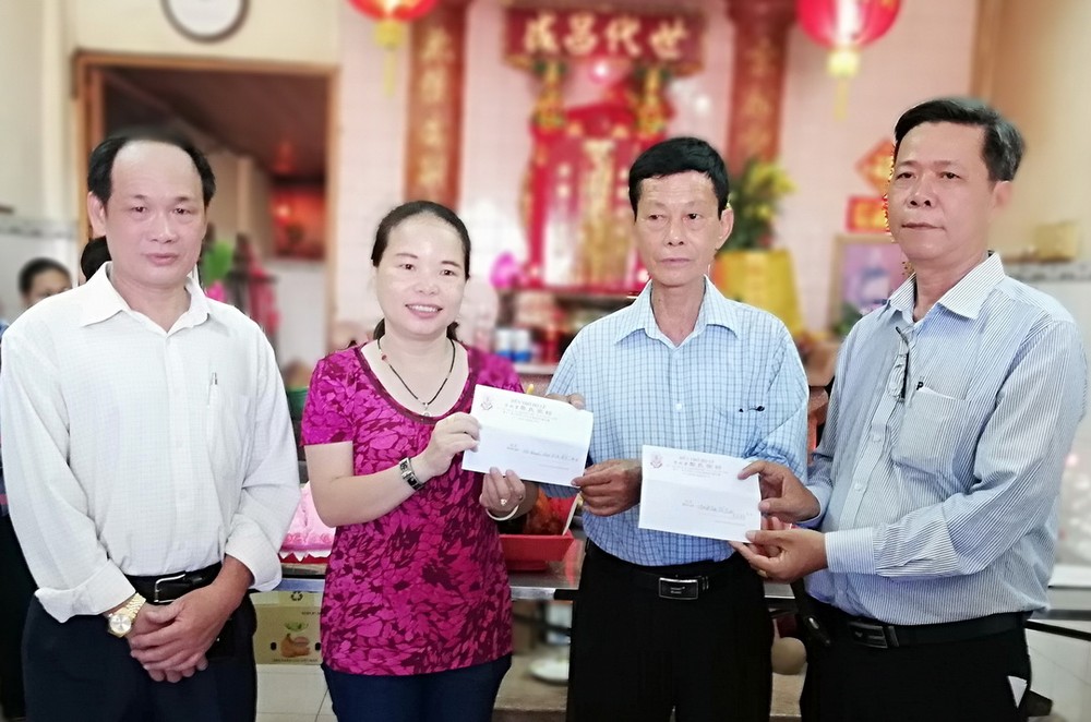 宗祠理事長黎志有(右一)把兩份善款交給 坊祖國陣線委員會主席黎氏金清水女士代收。