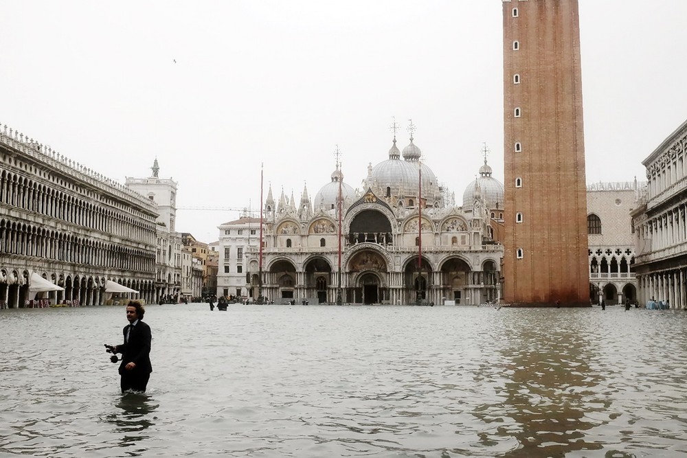 一名男子站立在聖馬克廣場積水中。（圖源：AFP）