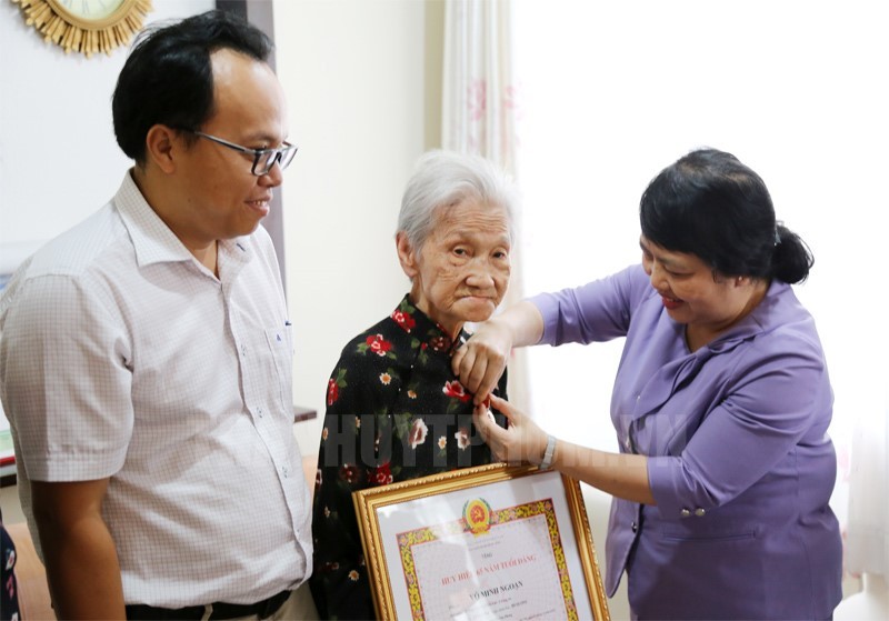 第七郡委常務副書記杜氏草代表郡委常務處向老前輩黨員頒授黨齡紀念章。（圖源：市黨部新聞網）