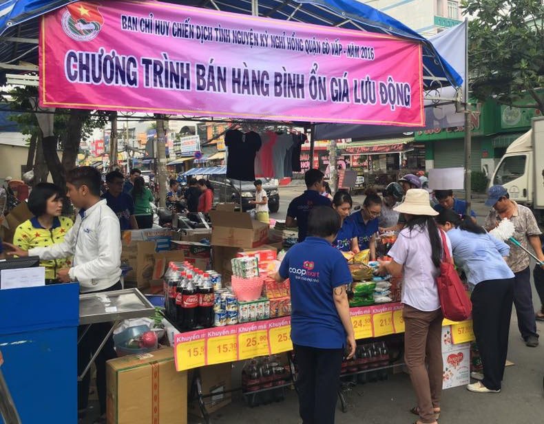 勞工在流動攤位選購平抑物價商品。