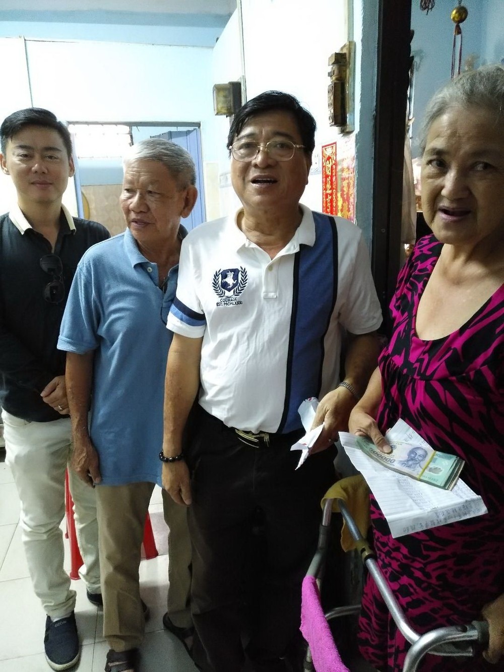 何氏宗祠理事長何冠忠偕眾理事親至何月梅宗親寄居處，遞交1640萬元捐款予何月梅。