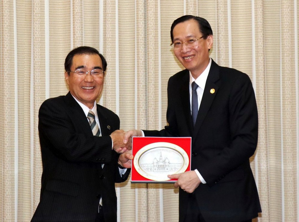 市人委會常務副主席黎清廉（右）向日本鹿兒島市市長森博幸贈送紀念品。（圖源：越通社）