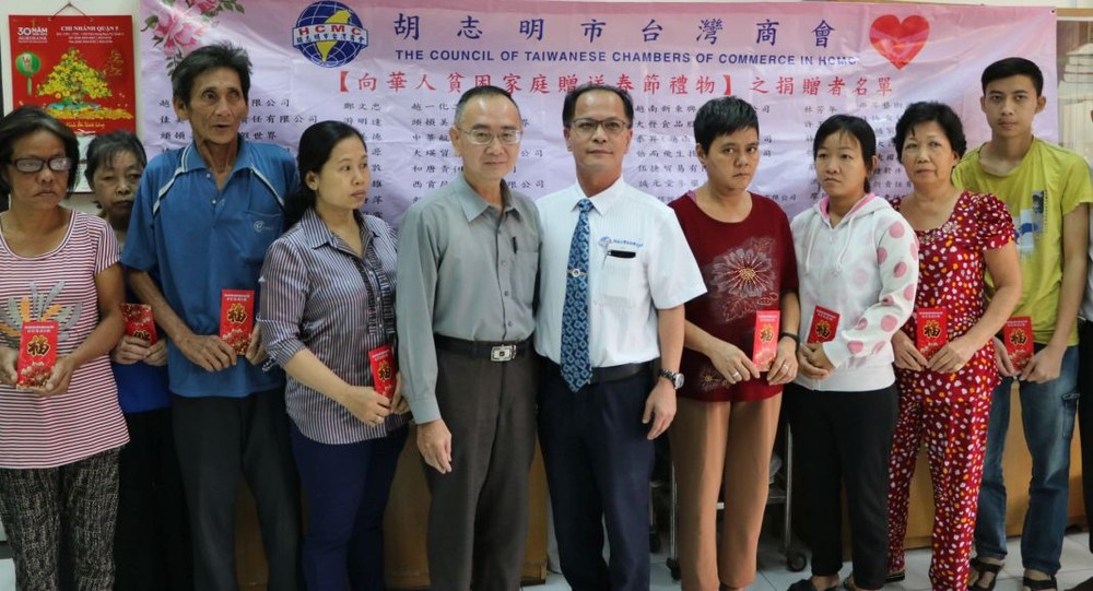 本報編委兼編輯部主任范興與台商會會長鄭文忠向第五郡華人貧困家庭贈送禮物。