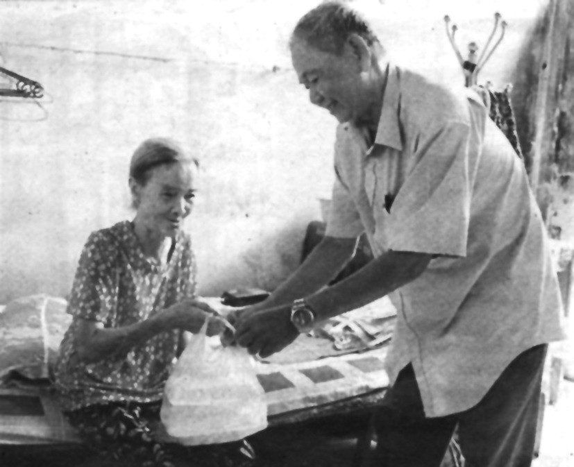 阮功化老大伯向獨居的阮氏蘭老婆婆送飯。