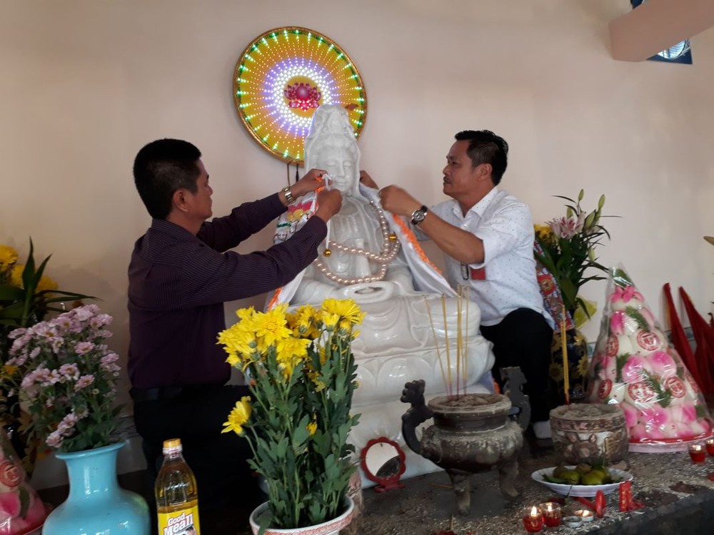 陳昶霖（右）為觀世音菩薩穿戴神袍。