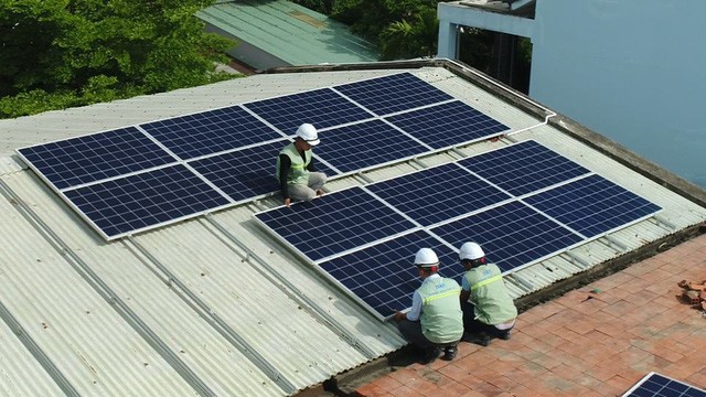 電工在給“五‧一五”學校安裝太陽能電池板。