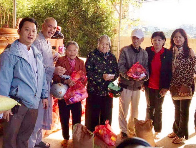 該廟慈善組組長鄒國榮（左一）與寶光浮寺的 振啟法師（左二）向少數民族同胞派發禮物。