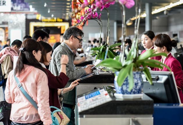 旅客在櫃台辦理登機手續。(圖源:新華社)