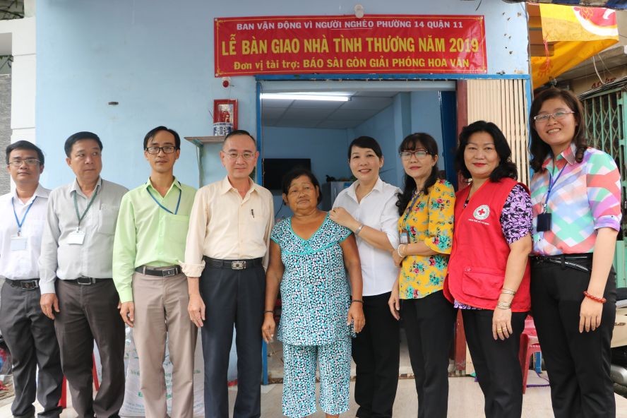 范興主任(左四)與地方領導同張南瑛(中) 在屋前留影。