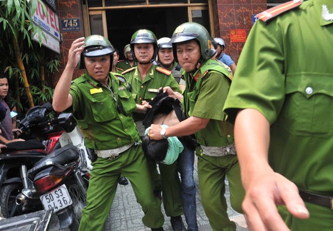 警方將抓獲的劫匪押出現場送往派出所。