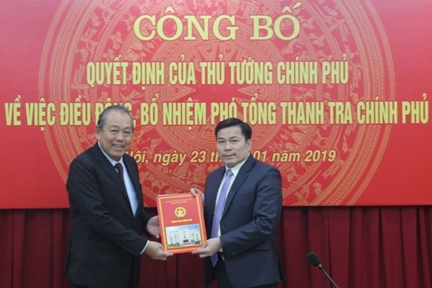 受政府總理委託，政府常務副總理張和平（左）向陳文明同志頒發政府總監察署副總監察職務委任《決定》。