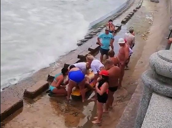 人們在給一名溺水者做人工呼吸。（圖源：L.V.Minh）