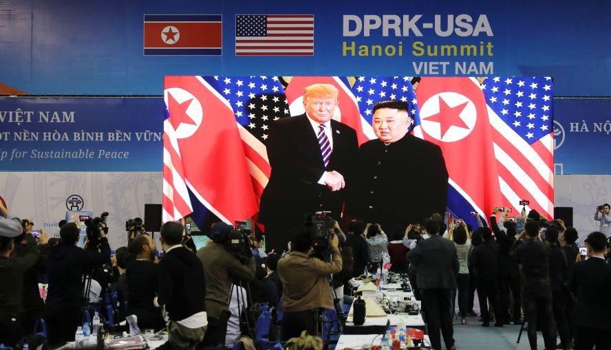 記者在國際新聞中心觀看和拍攝金正恩與特朗普會面的電視直播。(圖源:新華社)