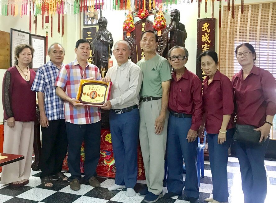 曾文良（左三）接受鄭成龍（左四）贈送紀念章。