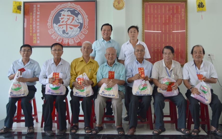 梁萬榮與梁國富正副理事長(後排)向長者們敬送禮物。