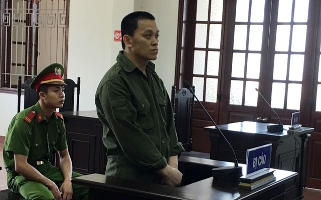 被告人何功慶站在被告席上答審判問案。（圖源：英豪）