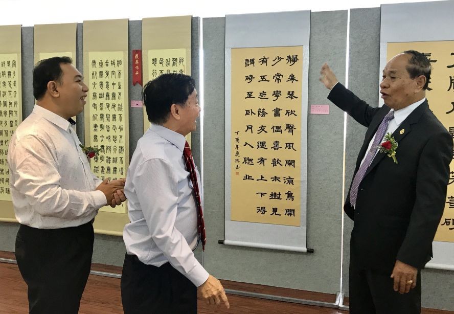 馮利發(左二)與林漢城(左一)陪同柬埔寨教育部國務秘書麥砂綸參觀越南區書法。