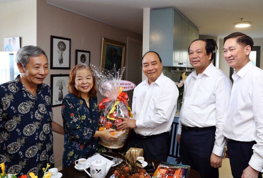 阮春福總理向資深新聞工作者贈送禮物祝賀。(圖源:越通社)