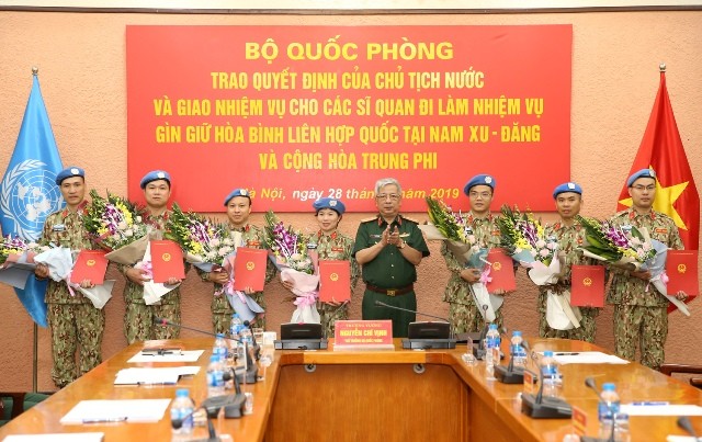 國防部副部長阮志詠上將向前往南蘇丹與中非共和國參與聯合國維和行動的軍官頒授國家主席《決定》和贈送鮮花祝賀。（圖源：嬌江）