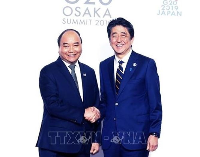 政府總理阮春福(左)與日本首相安倍晉三握手。(圖源:越通社)