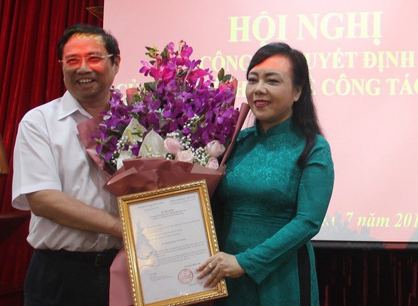 衛生部長阮氏金進（右）從黨中央政治局委員、中央組織部長范明正手中接過委任《決定》及祝賀鮮花。（圖源：L.K）