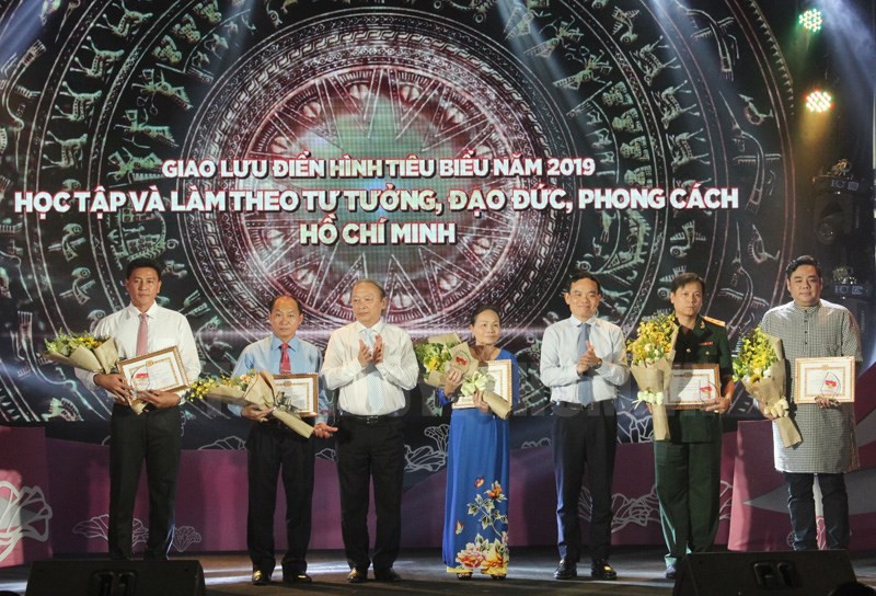 中央宣教部副部長武文鋒（左三）、市委常務副書記陳留光（右三）向學習與傚法胡志明思想、道德、作風取得成績的5位典範人士頒授紀念章和證書並贈送鮮花祝賀。（圖源：長黃）