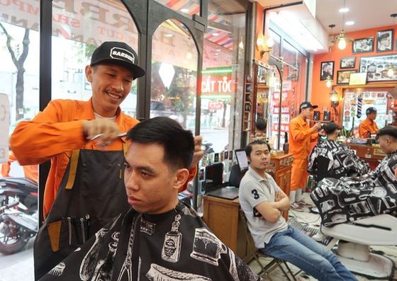 鄭懷清正給客人理髮。