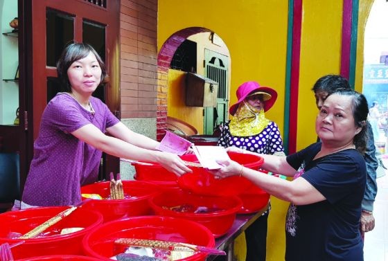 善信在溫陵會館領取“合家福物”以上香膜拜。