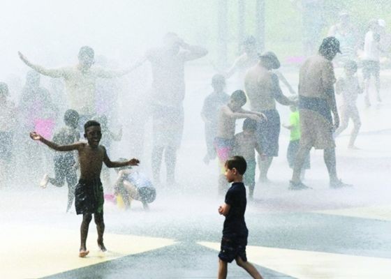 市民在噴水設施除去外衣消暑。（圖源：互聯網）
