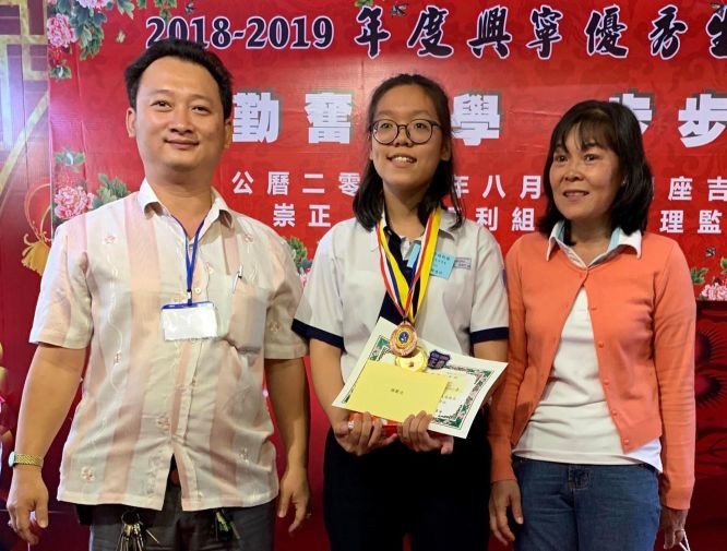 崇正興寧福利組理事長鄒國榮(左一) 向模範生鍾貴彩頒發獎學金。