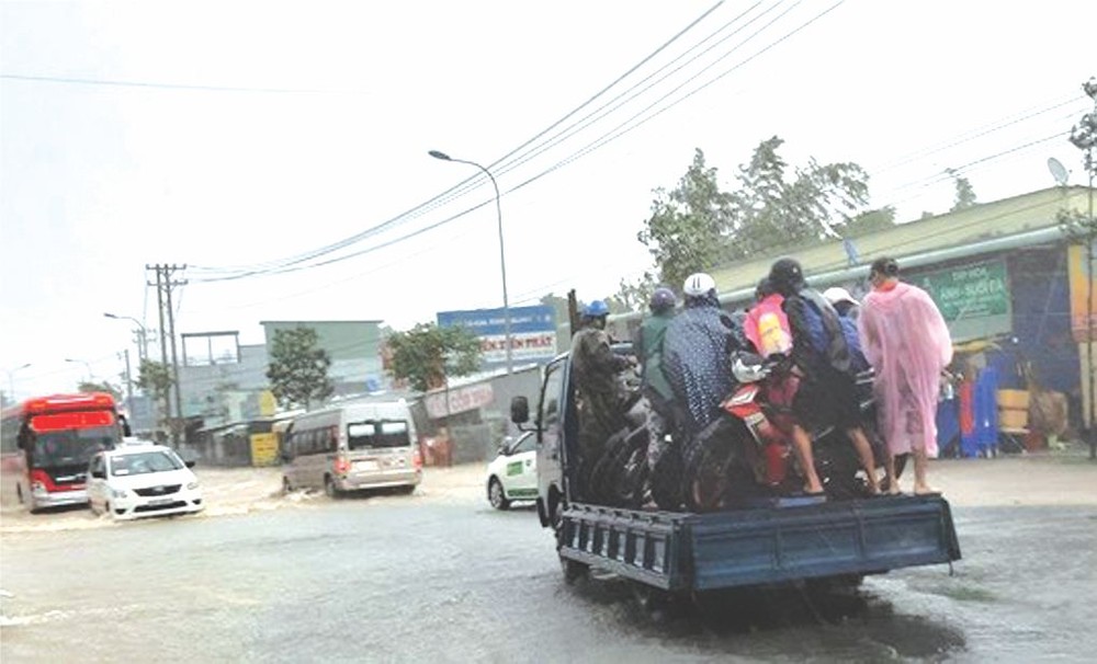 各職能部門和民眾須用卡車運載摩托車越過四月三十日街的水深路段。（圖源：互聯網）