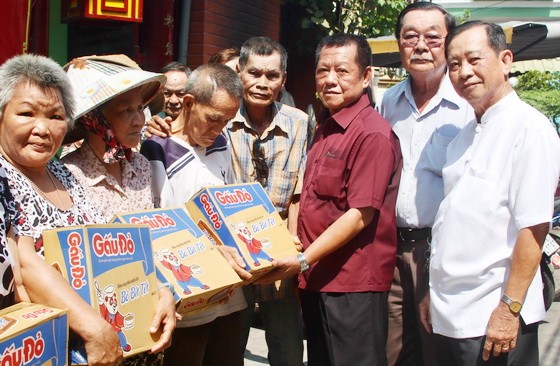 浸石天后宮理事長張敬和(右三)與各副理事長 向貧困同胞派發禮物。