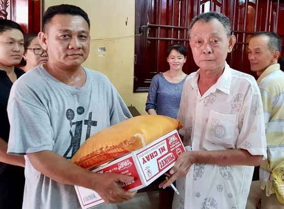 沙瀝市明月居士林林長江忠盛(右)向窮人發禮品。