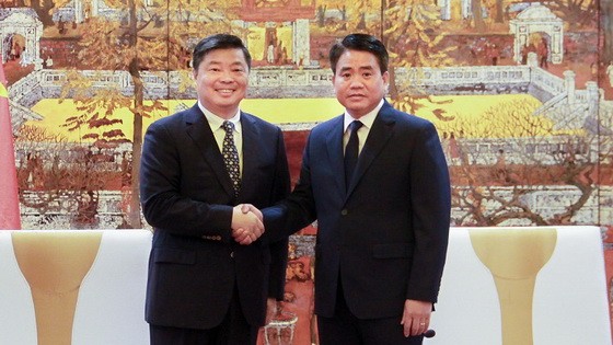 河內市人委會主席阮德鍾（右）與中國廣東省副省長歐陽衛民握手合影。（圖源：秀英）