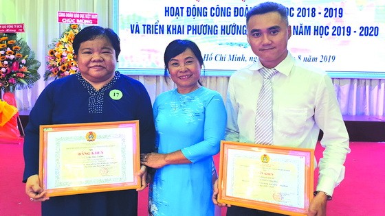 市教育與培訓廳工會主席阮氏女向市華語成人教育中心工會頒發“出色工會”集體獎。