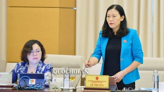 國會司法委員會主任黎氏娥闡（右）在會議上述政府對肅貪工作的審查《報告》。（圖源：Quochoi.vn）