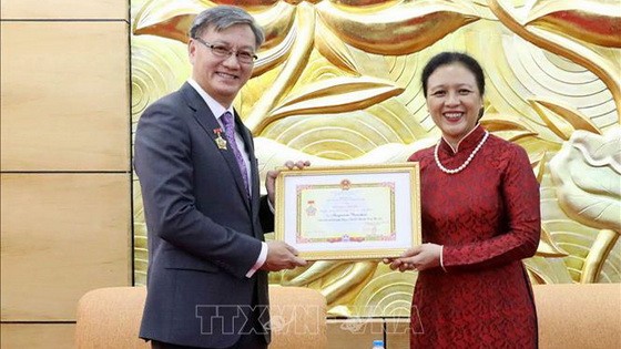 越南各友好組織聯合會主席阮芳娥（右）向老撾駐越南大使通沙萬‧豐威漢頒贈“為各民族之間和平友好”紀念章。（圖源：越通社）