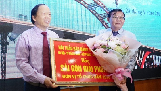 《海防報》總編輯向《西貢解放報》總編輯阮晉豐(右)轉交下一次座談會舉辦權。（圖源：杜忠）