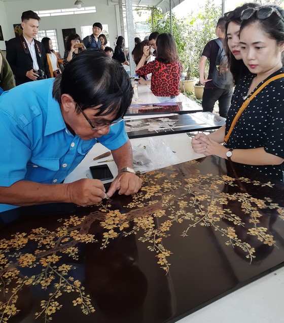 遊客正參觀該省土龍木市的 定和磨漆公司。